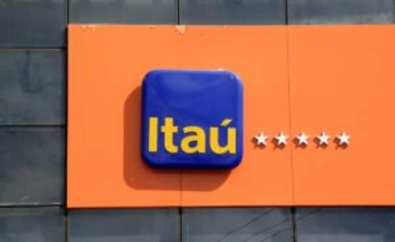 Fachada com letreiro do Itaú em amarelo, azul e laranja. Fundo preto