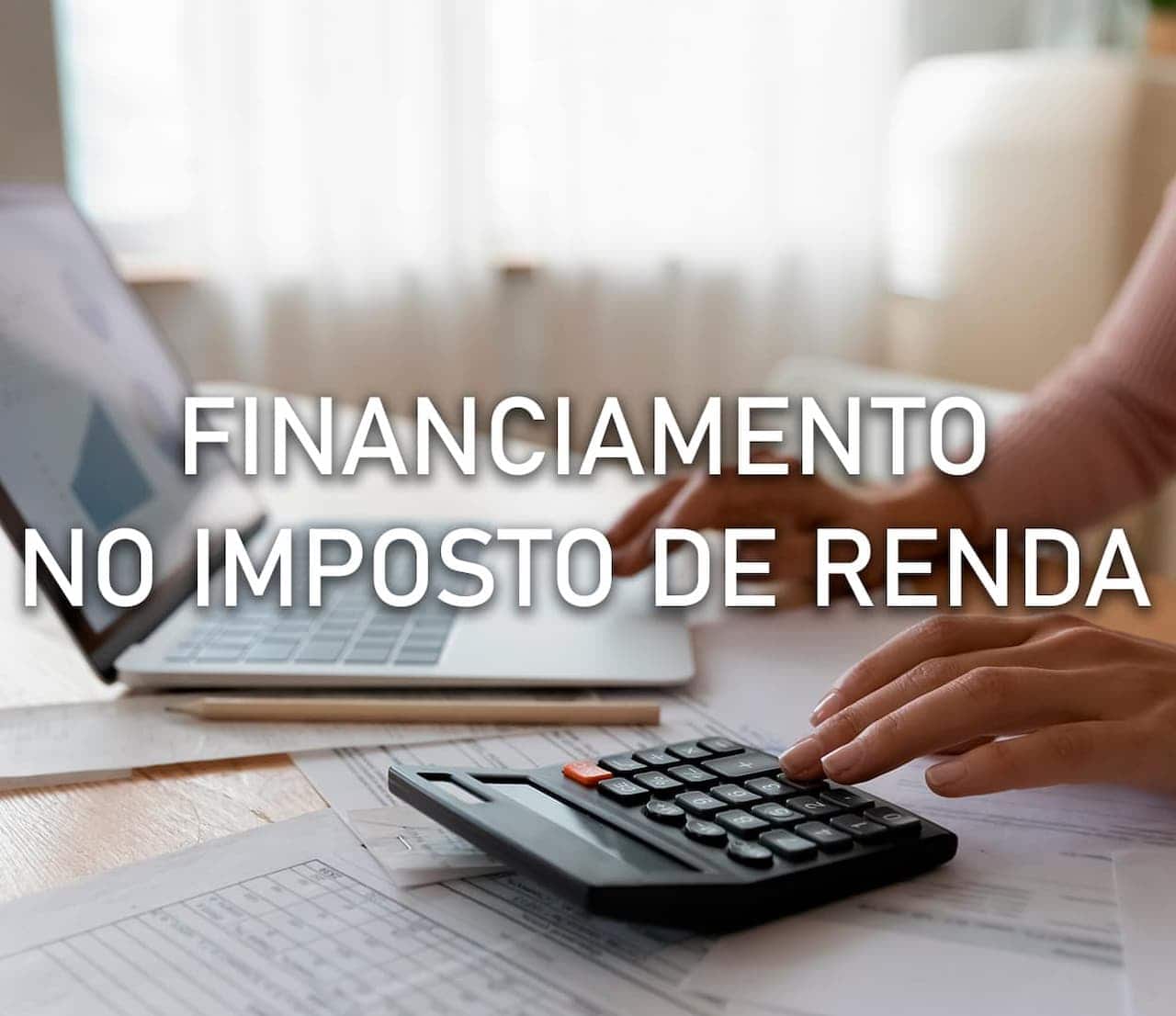 Pessoa usando uma calculadora enquanto faz a declaração do Imposto de Renda no computador. Em frente à imagem a frase "financiamento no imposto de renda"
