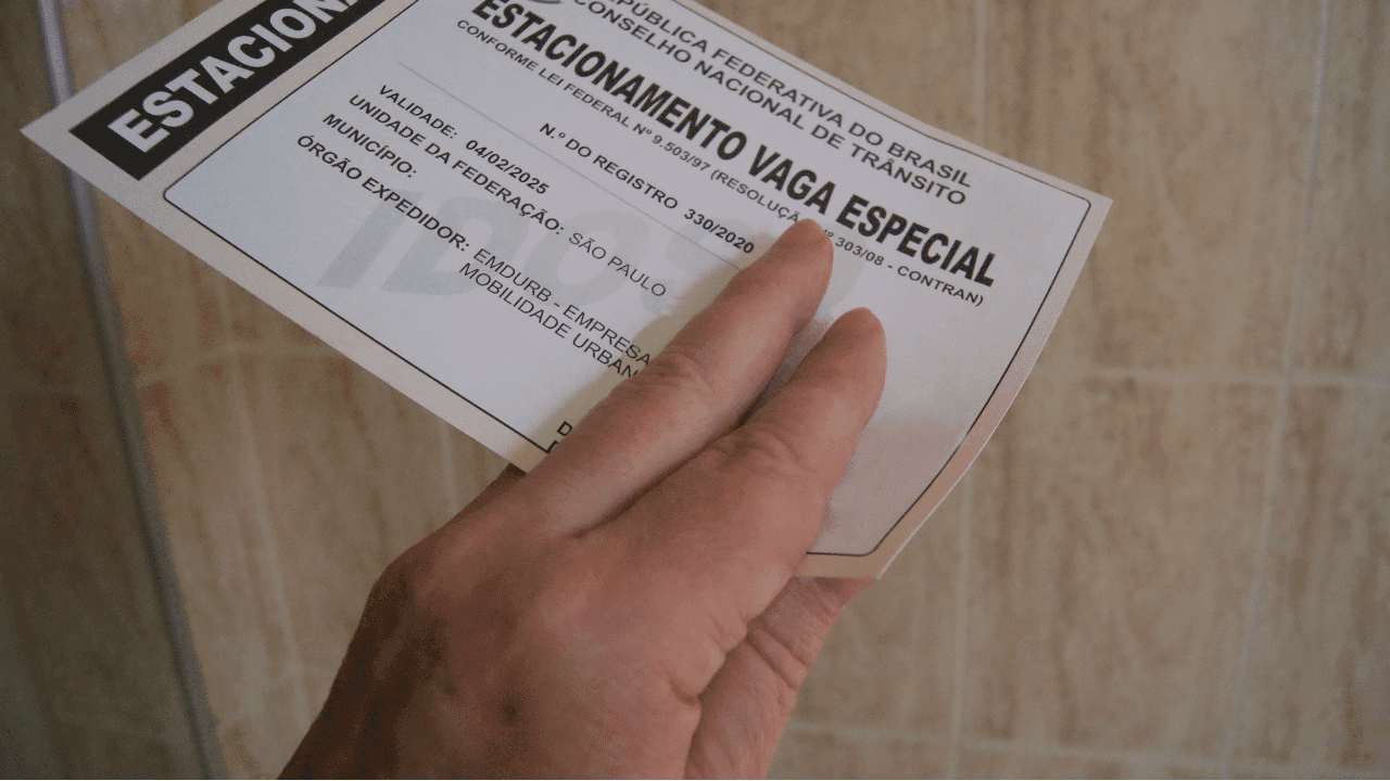 Imagem de idosa segurando o documento de estacionamento para idosos