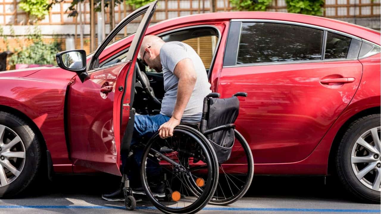 Tetraplégico entrando com cadeira de rodas em carro vermelho