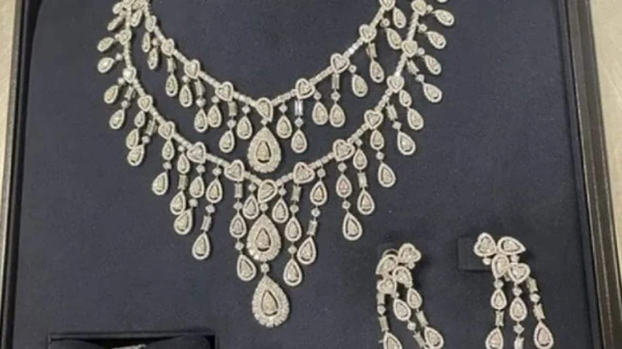 Conjunto de joias de Michelle Bolsonaro posto em um suporte azul