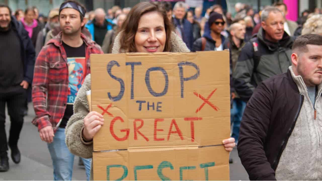 Manifestante segurando um cartaz dizendo 'STOP THE GREAT RESET' no Vigil for the Voiceless, protesto anti-lockdown em Londres