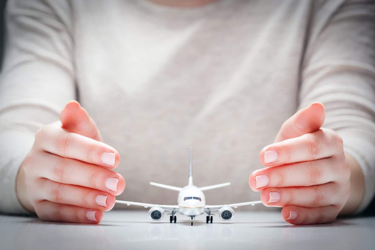 Mãos protegendo avião em miniatura aviação