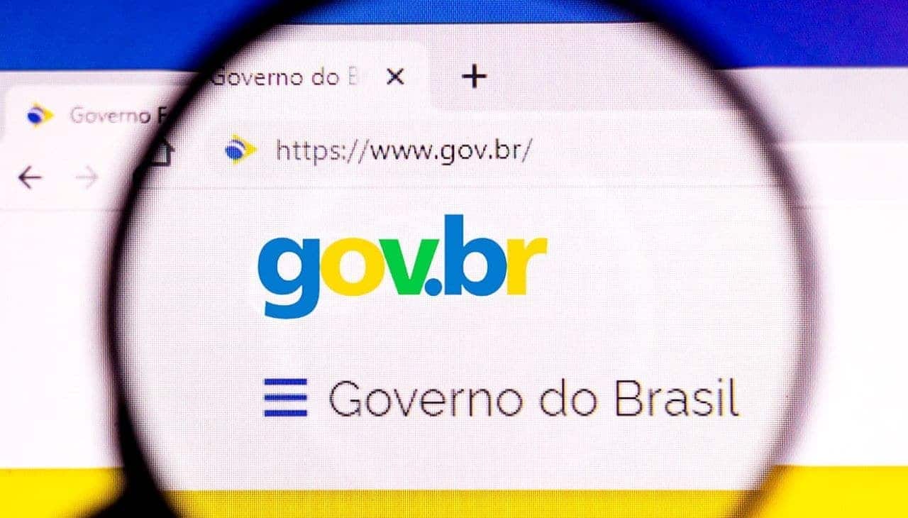 Lupa aumentando uma parte de um monitor que exibe o portal do governo federal, que pode ser acessado com conta bancária
