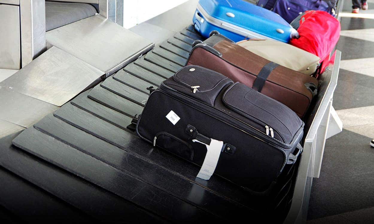 Imagem mostra diversas malas emparelhadas em uma esteira no aeroporto.