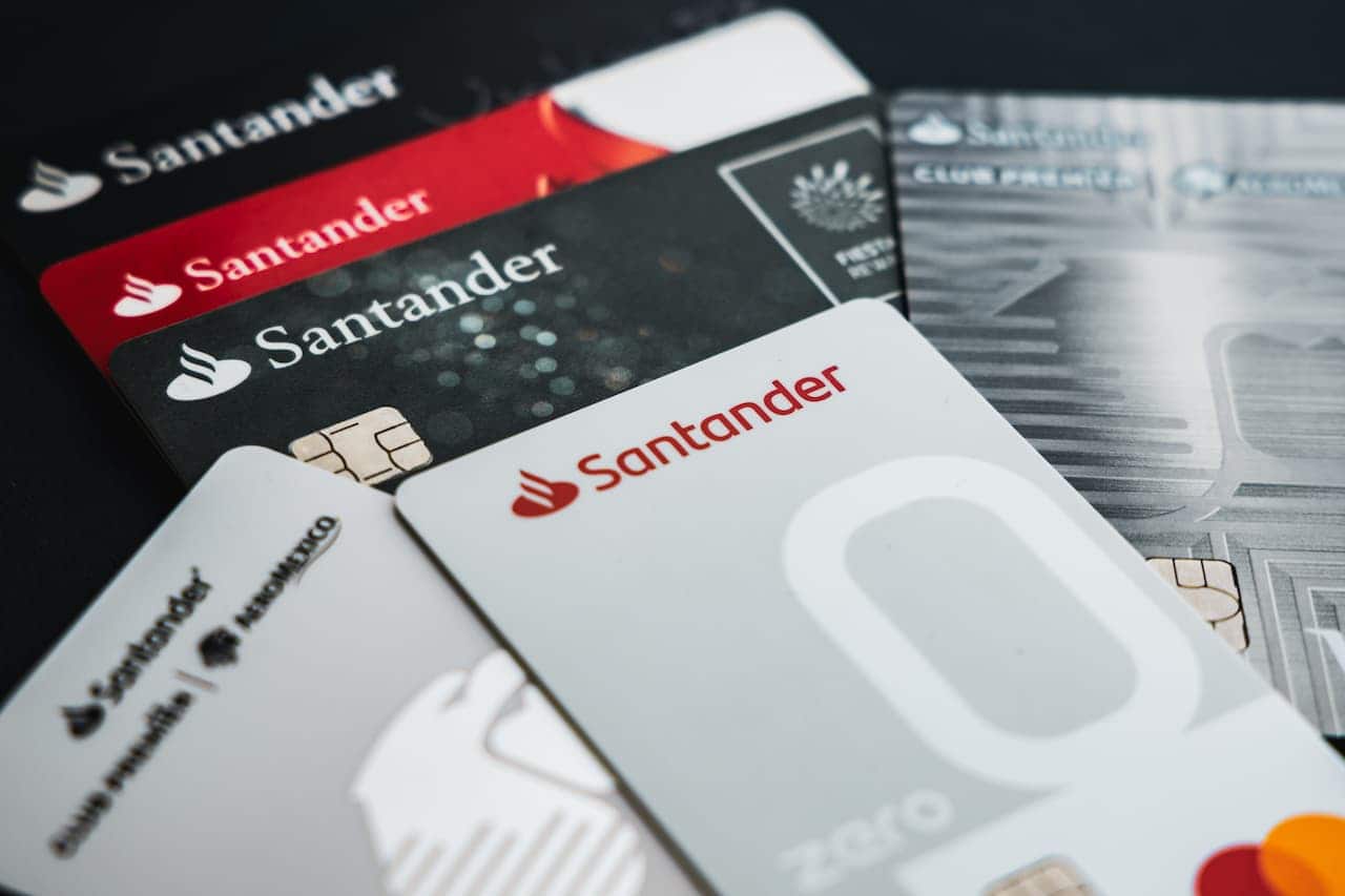 Vários cartões do banco Santander, em diversas cores e bandeiras.
