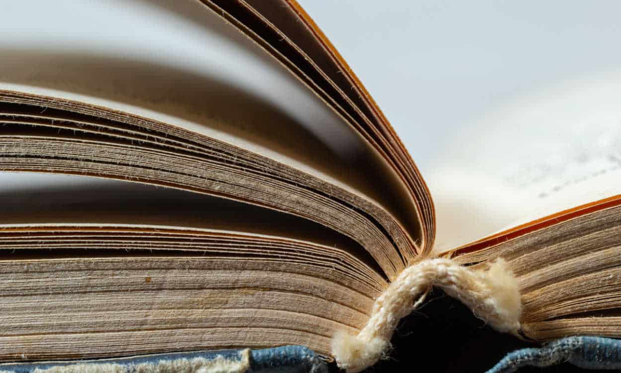 Livro antigo aberto com as páginas amareladas e a capa gasta