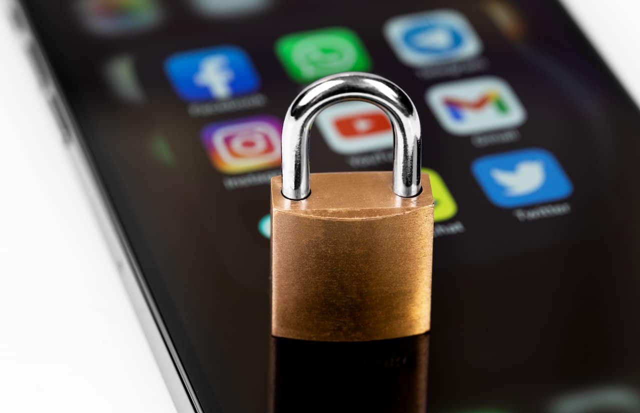 Um pequeno cadeado sobre um celular que tem redes sociais em evidência em sua tela instagram