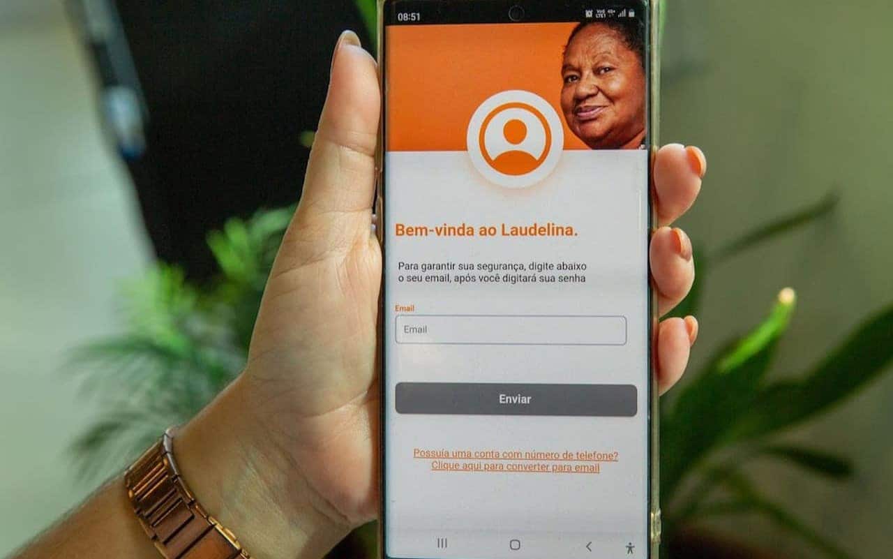 Aplicativo para domésticas Laudelina aberto em um celular que está sendo segurado por uma mão