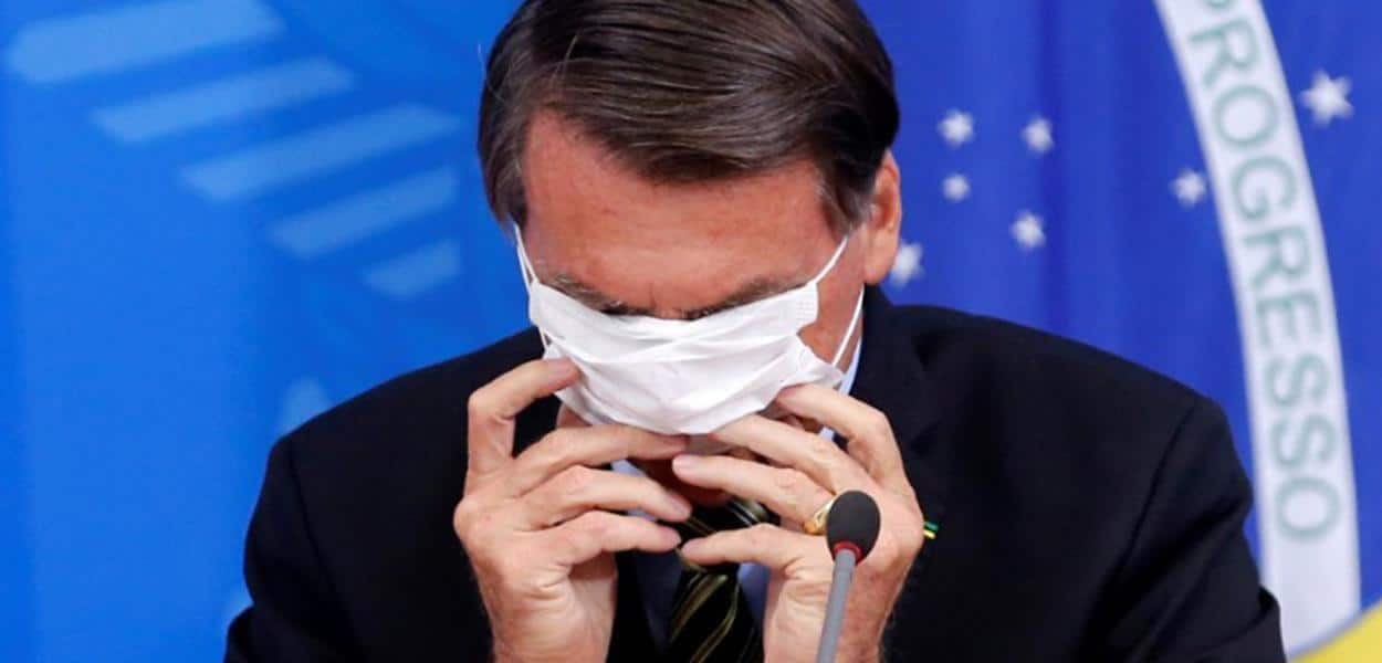 Bolsonaro com dificuldade de colocar máscara de proteção