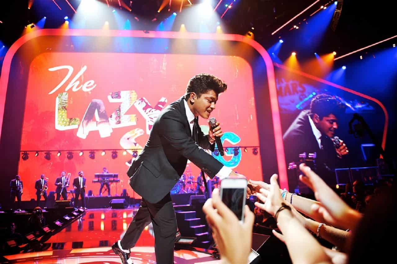 Bruno Mars cumprimenta fãs em show.