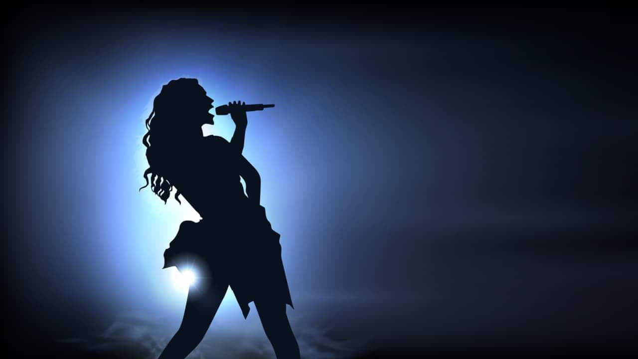 silhueta de cantora no palco com microfone