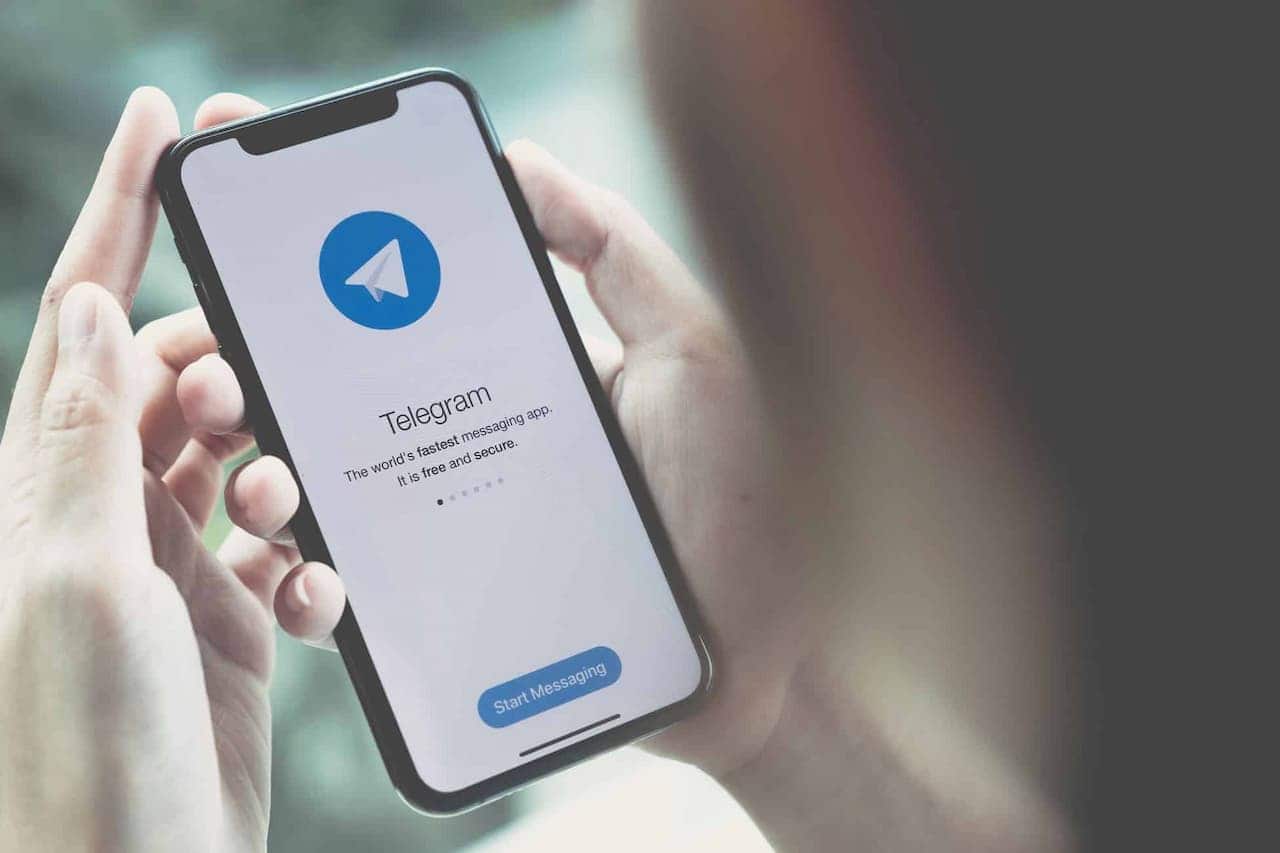 Pessoa segurando um celular com aplicativo do Telegram aberto