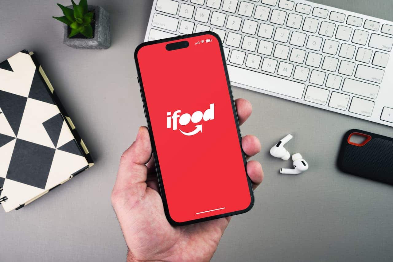 mão segurando celular com iFood