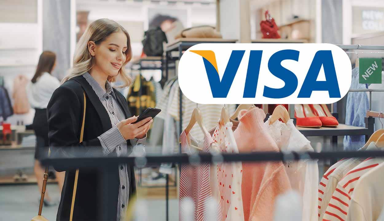 Mulher sorrindo segurando o celular ao lado do logo da Visa
