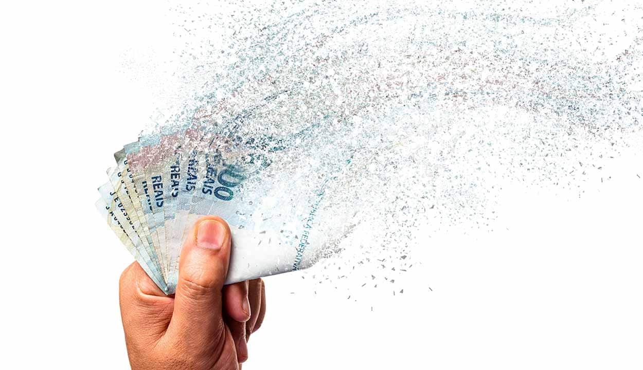 Dinheiro em espécie na mão de uma pessoa desaparecendo