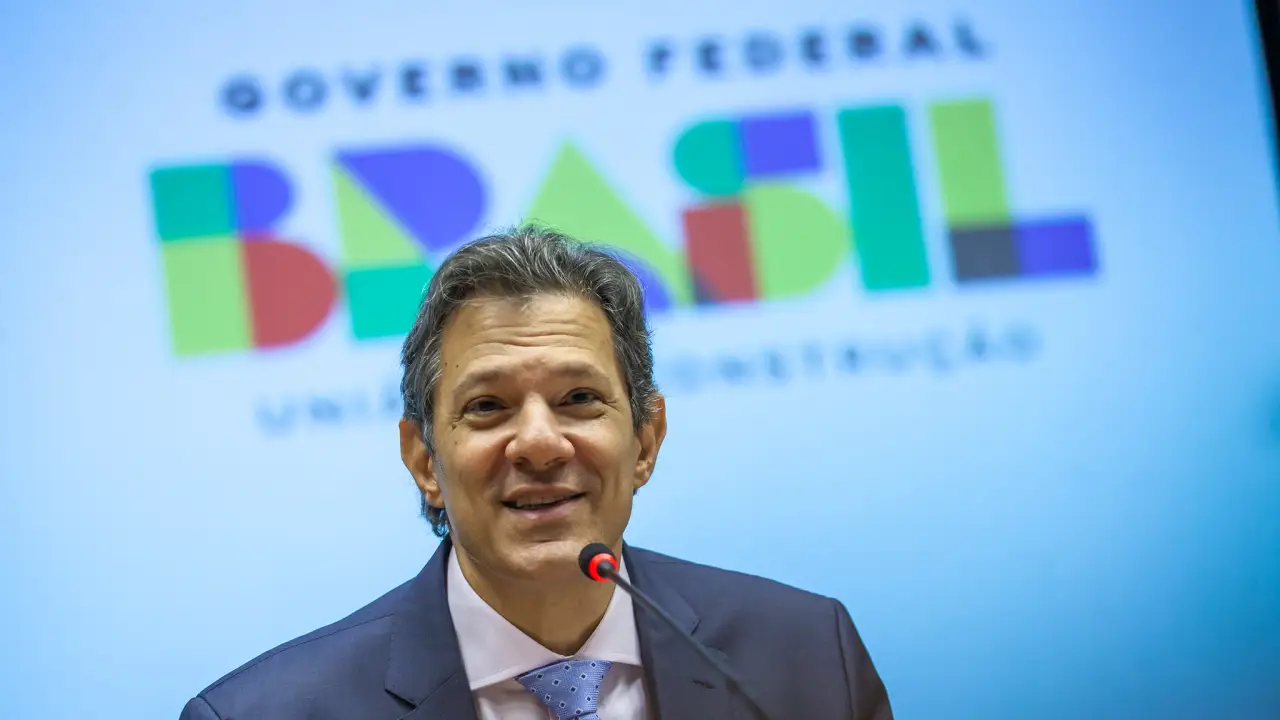 Imagem do ministro da Fazenda, Fernando Haddad, sorrindo durante evento.