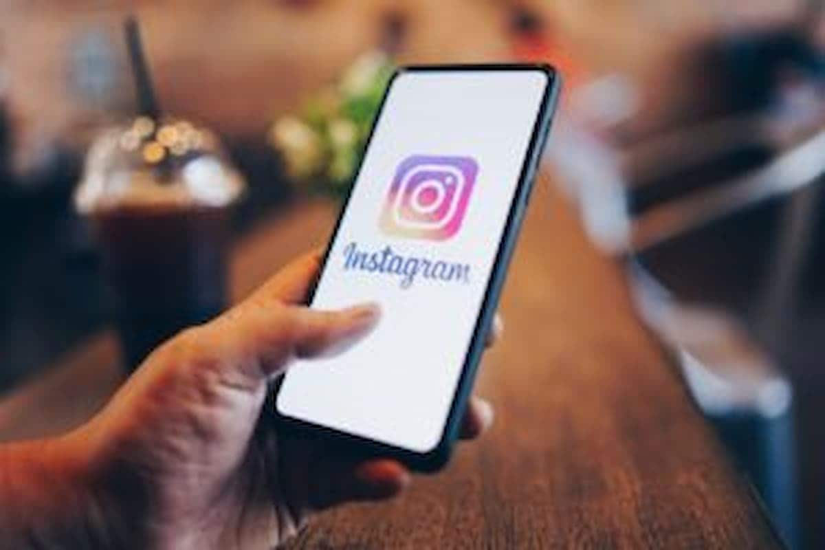 Mão segurando celular com aplicativo do Instagram na tela