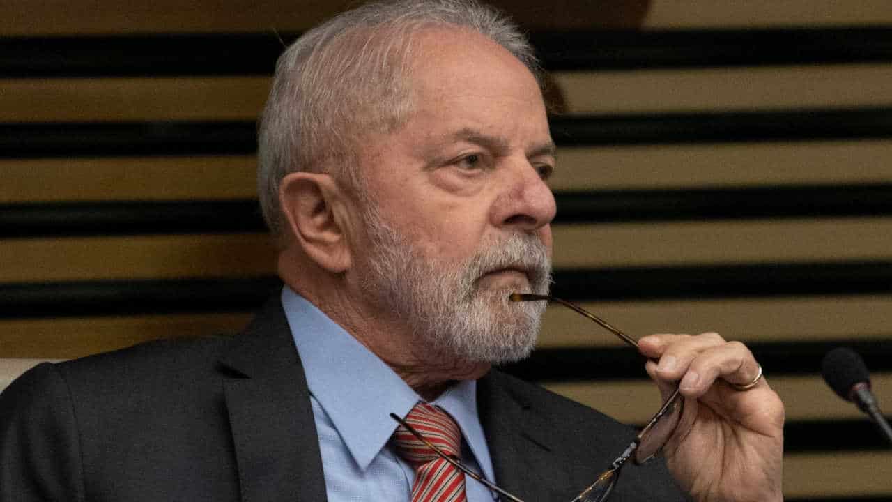 presidente Lula pensativo, segurando o óculos