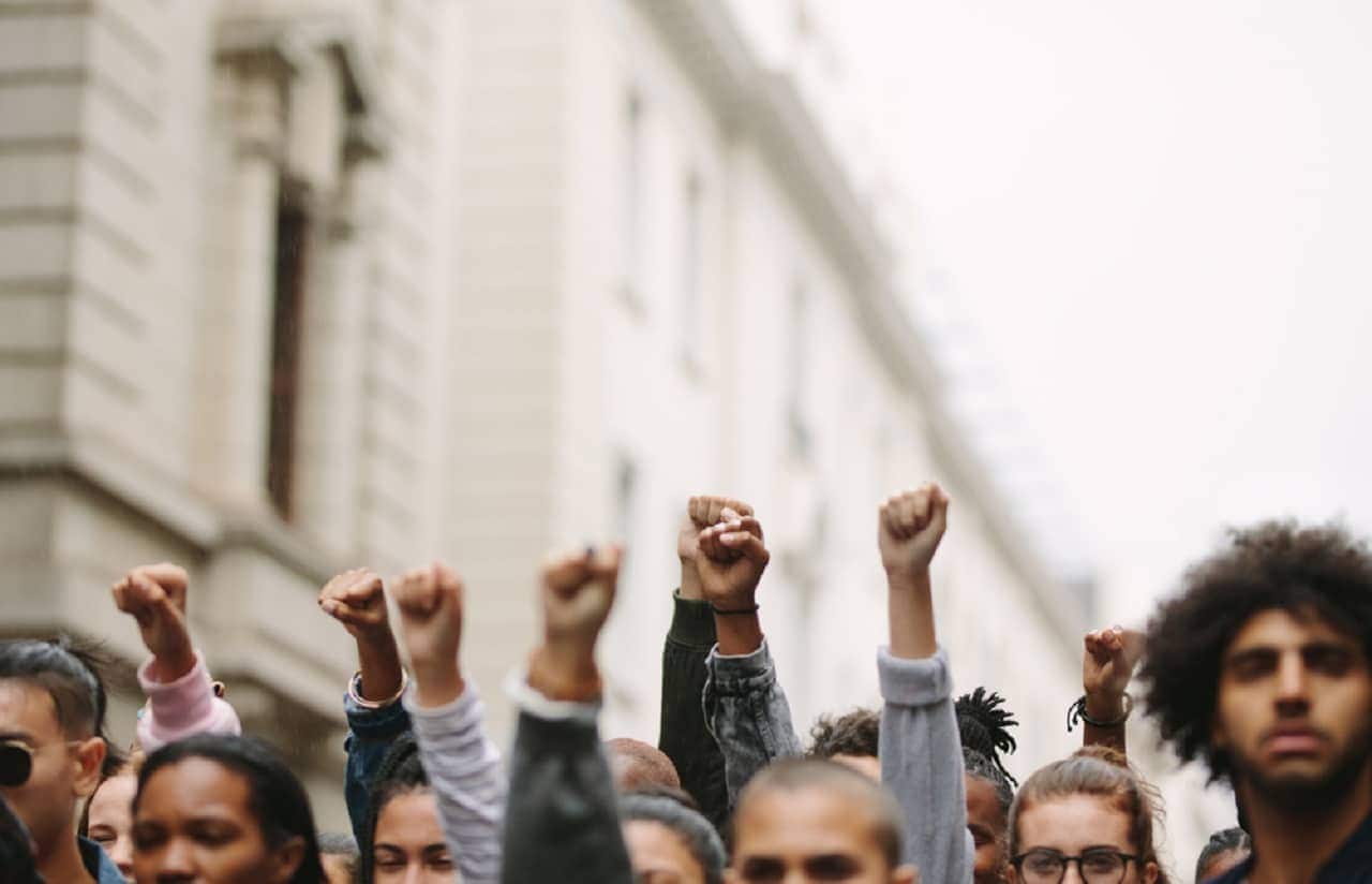 Imagem de várias pessoas com punho cerrado em uma greve
