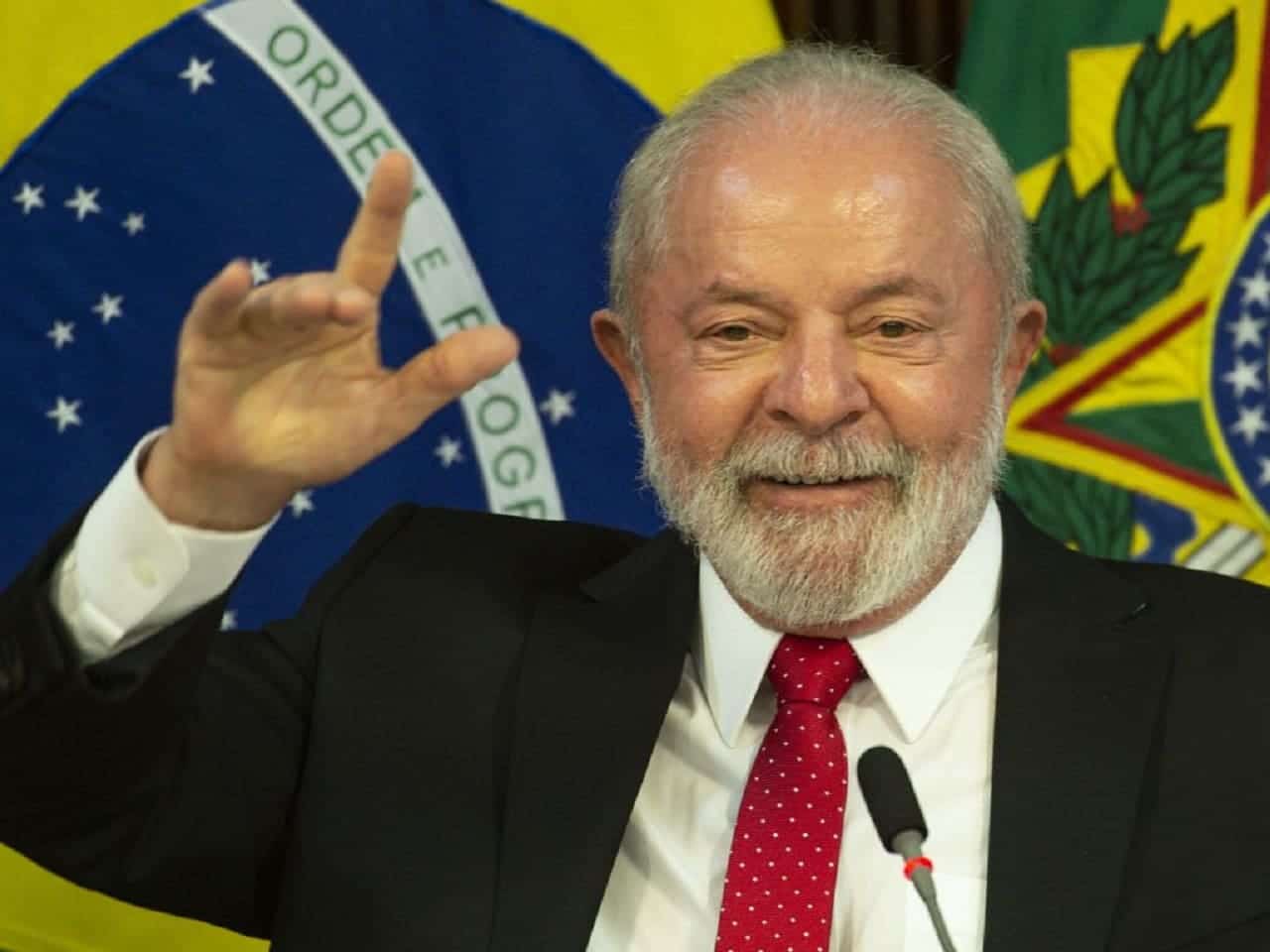 Imagem do presidente Lula sorrindo e acenando.
