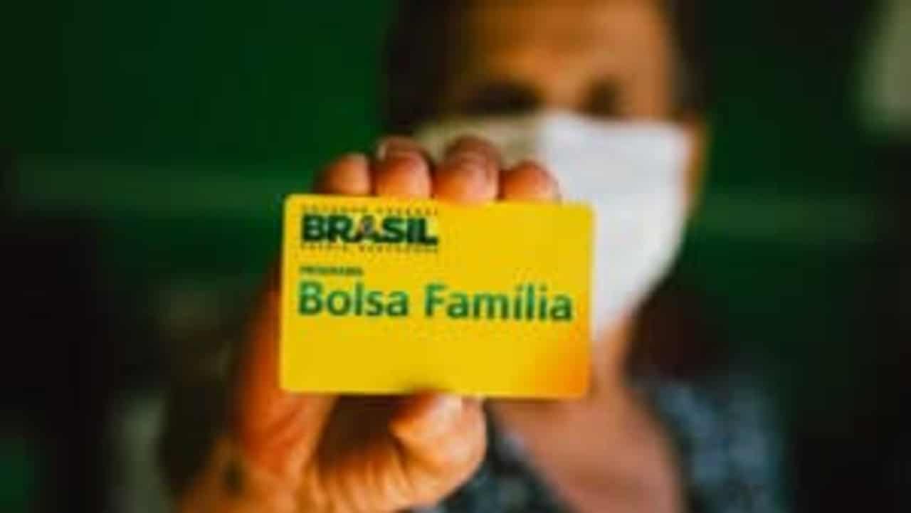 mulher segurando cartão do bolsa família