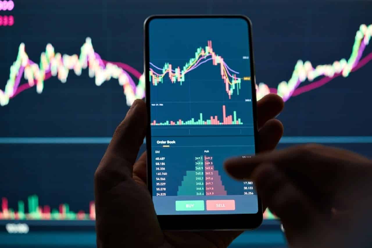 Imagem de alguém operando na bolsa pelo celular.