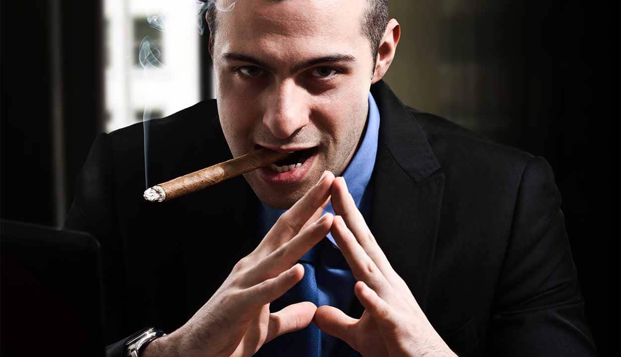 homem de terno, charuto e semblante malicioso