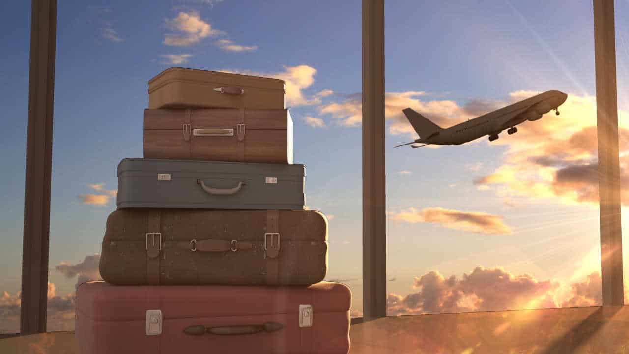 malas de viagem e avião voando ao fundo no céu