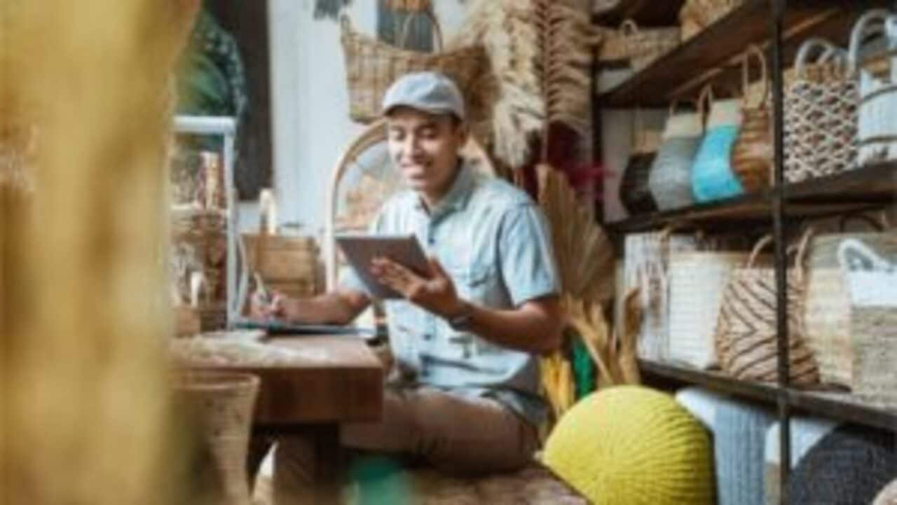 empreendedor sorri enquanto lê no tablet