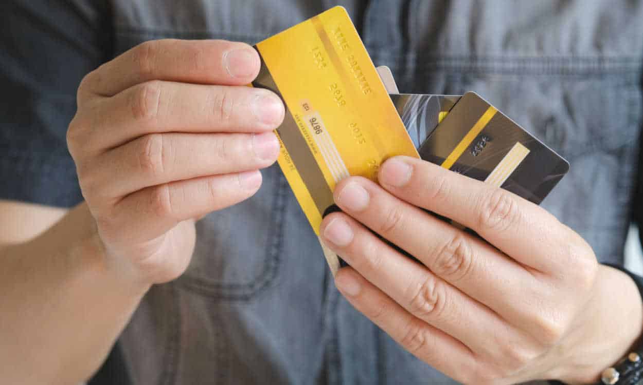 Homem com vários cartões de crédito na mão escolhendo um