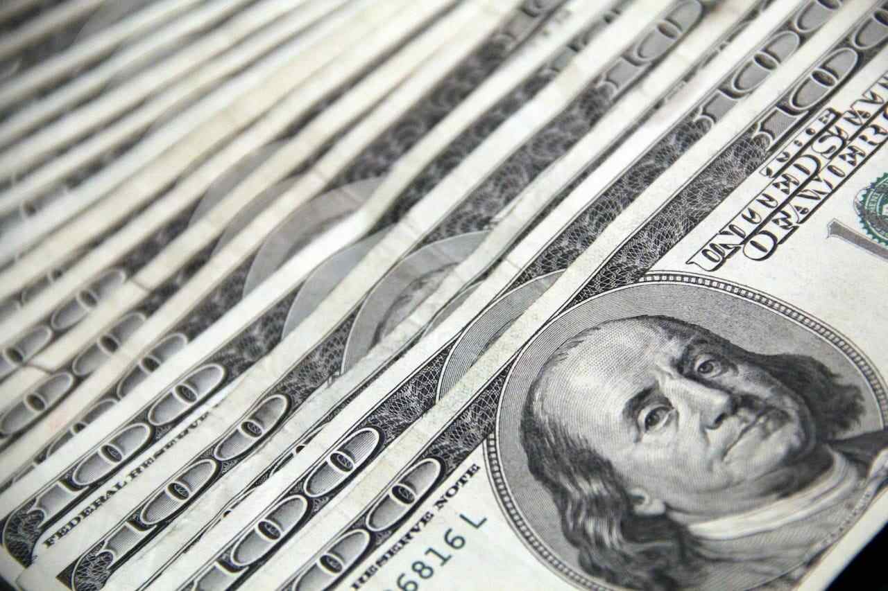 Uma série de notas de 100 dólares postas em fileiras.