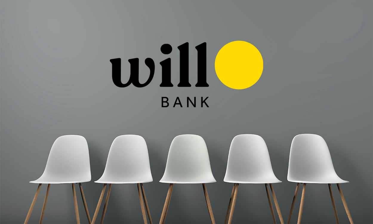 Cadeiras brancas diante de uma parede cinza com o logo do will bank