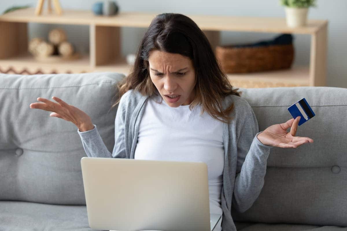 Cliente de banco assustada com cartão na mão