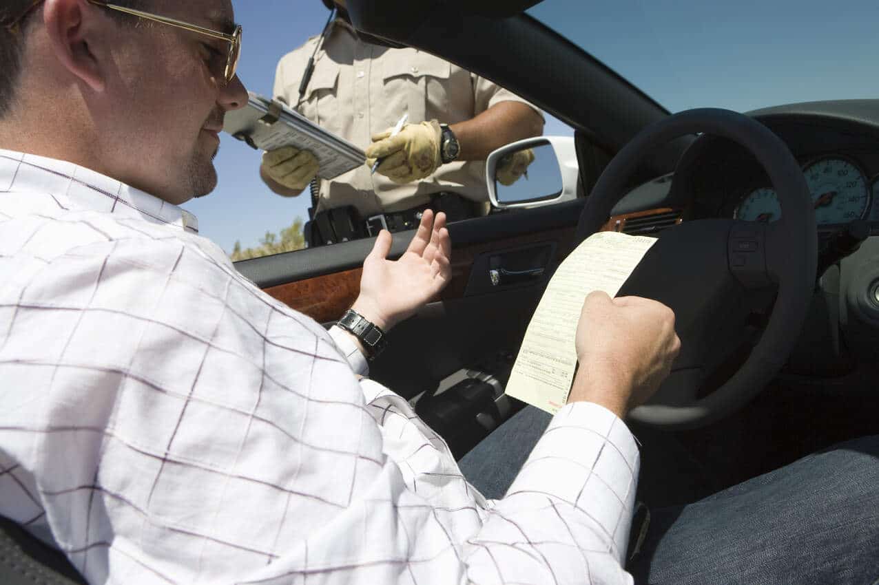 Motorista abordado por agente de trânsito recebendo multa.