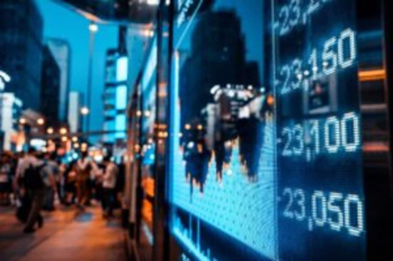 Imagem de um painel, posto em uma rua, com gráficos do mercado.