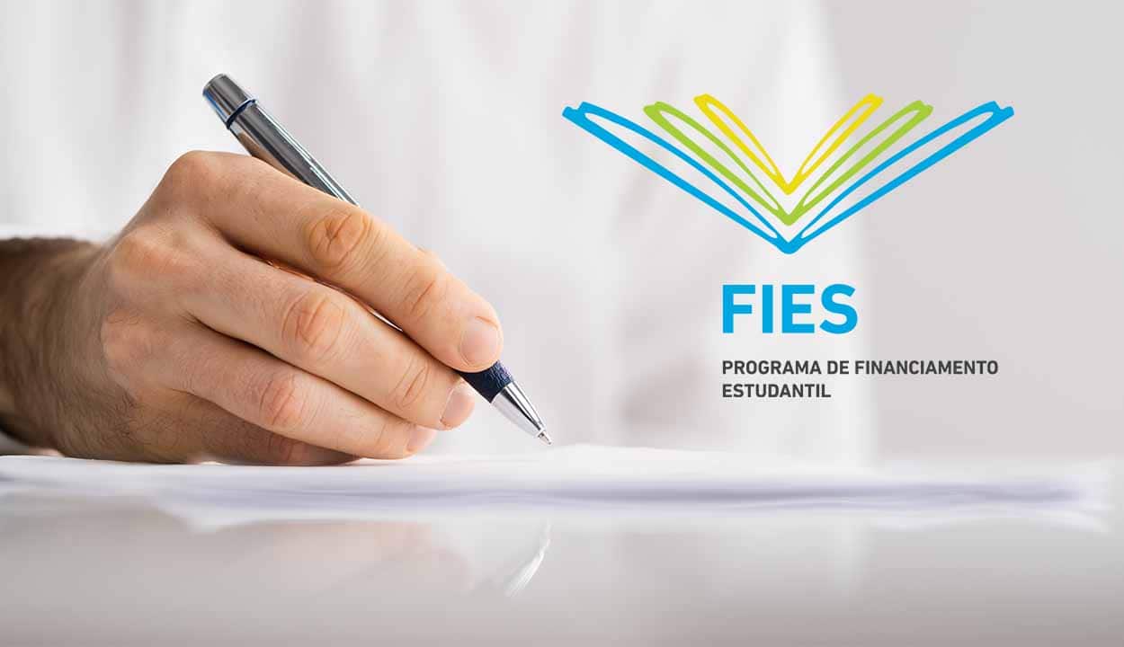 Imagem de uma mão segurando uma caneta enquanto escreve em uma folha de papel. No lado direito da imagem, há a logo do Fies.