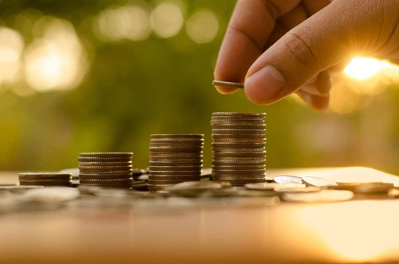 Imagem de uma pessoa empilhando moedas.
