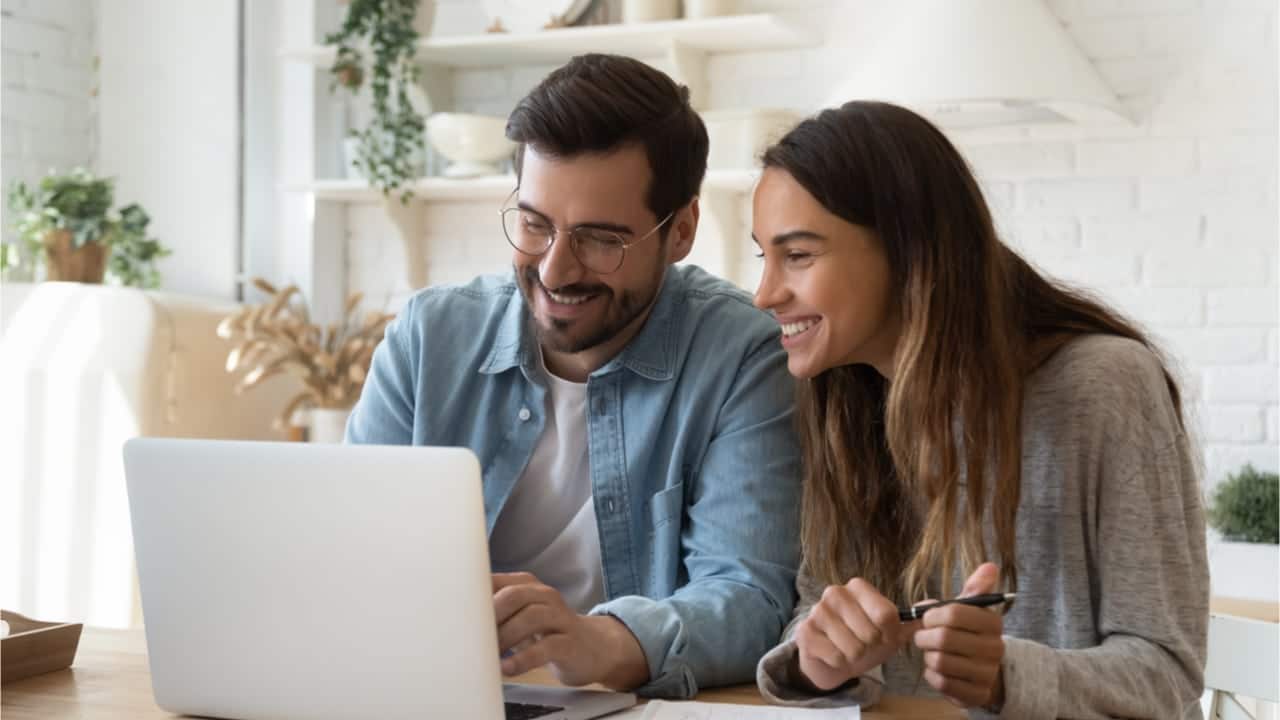 Imagem mostrando casando feliz olhando para computador