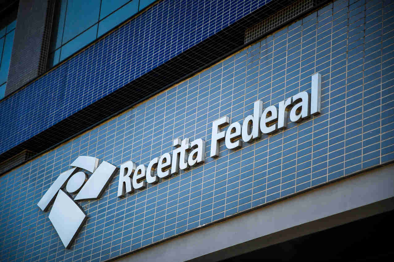 Fachada de uma agência da Receita Federal, com ladrilhos azuis e o nome na parede.