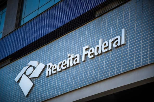 Fachada de uma agência da Receita Federal, com ladrilhos azuis e o nome na parede.