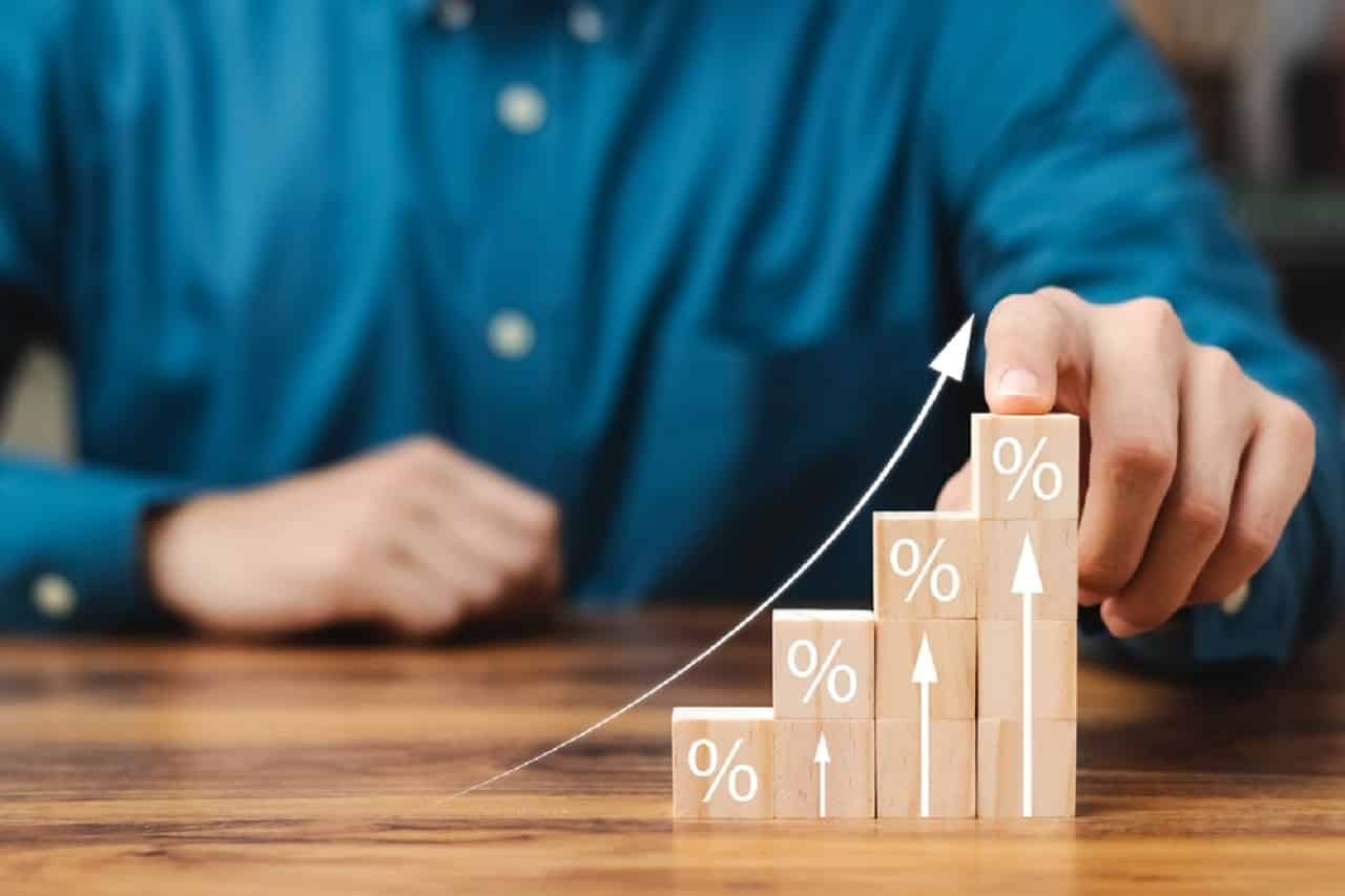 Imagem de uma pessoa segurando blocos que indicam um movimento gráfico de alta
