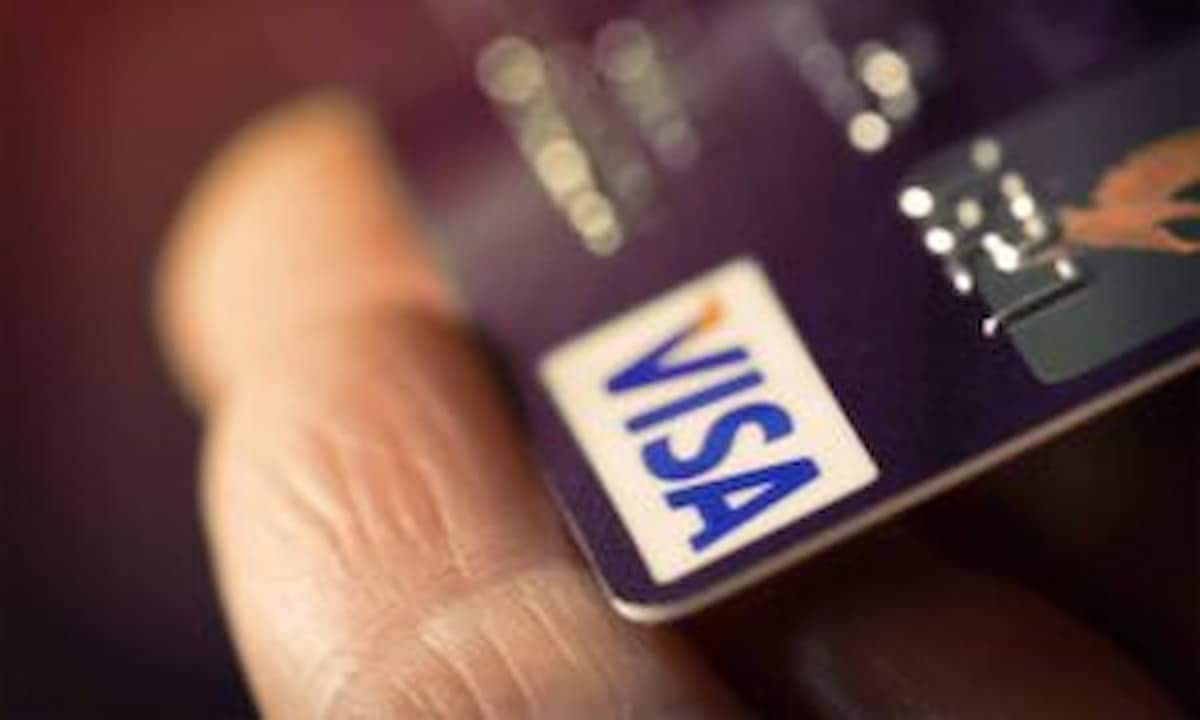 Cartão Visa na mão de pessoa