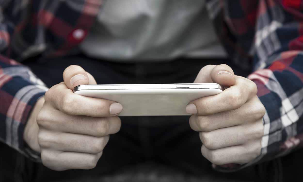 Imagem de adolescente segurando celular.