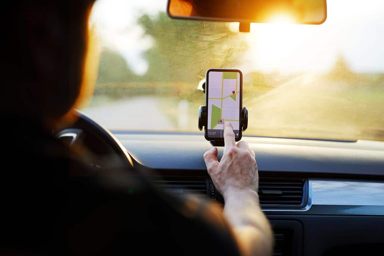 Motorista de app de veículo particular com o dedo no aplicativo do celular waze