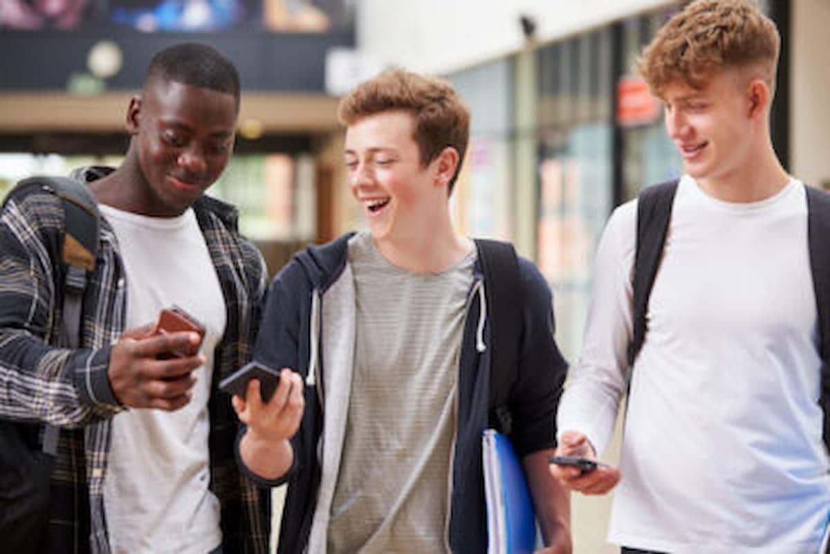 Três adolescentes europeus surpresos positivamente olhando o celular teens