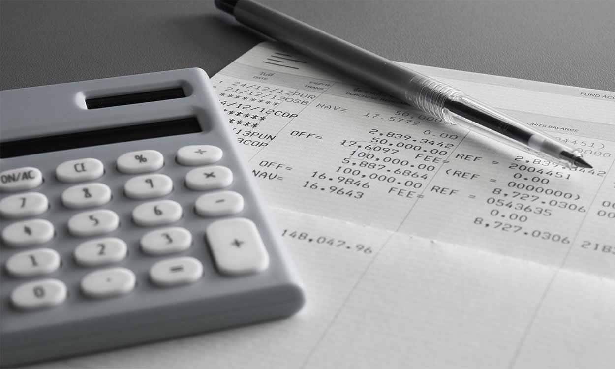 Calculadora ao lado de caneta e paoel