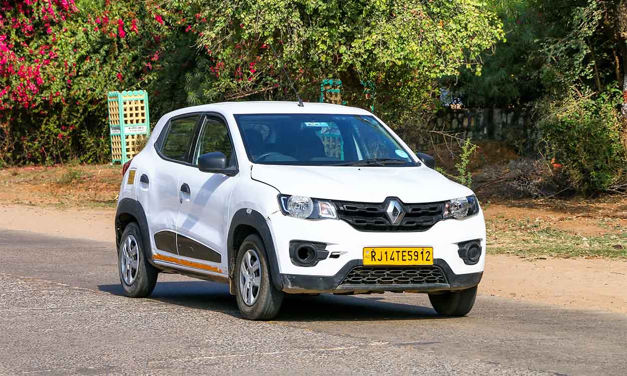 Carro Renault modelo Kwid Zen da cor branca parado em rua.