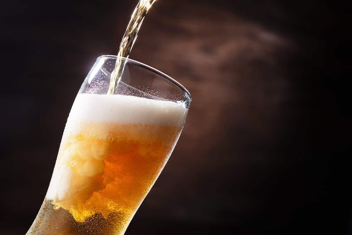 Um copo sendo preenchido com cerveja. imposto