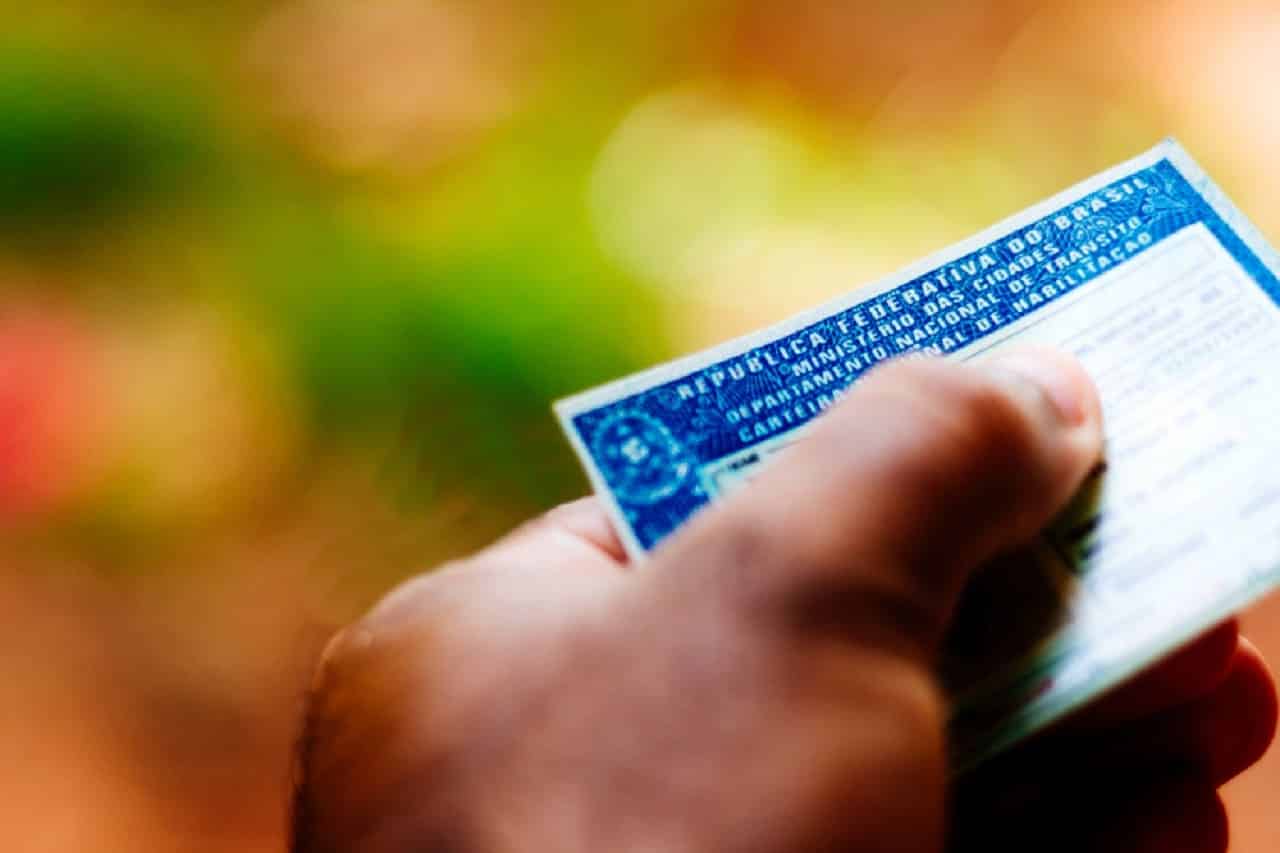 Imagem de uma mão segurando uma CNH